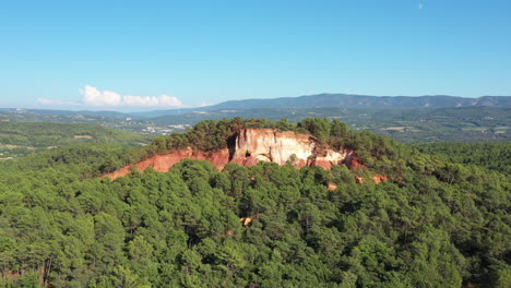 Aerial-landscape-with-mountains-and-trees-red-cliffs-ochre-of-Roussillon-famous